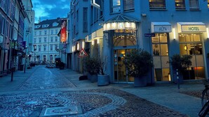 A hotel with a prominent 'HOTEL' sign, cobblestone street, and classic European architecture. - Alfa Hotel (Karlsruhe)