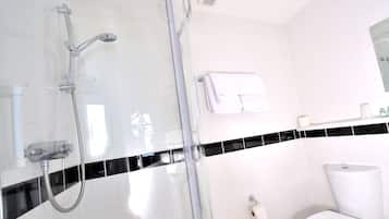 A modern bathroom with a glass shower enclosure, a toilet, and a towel rack.