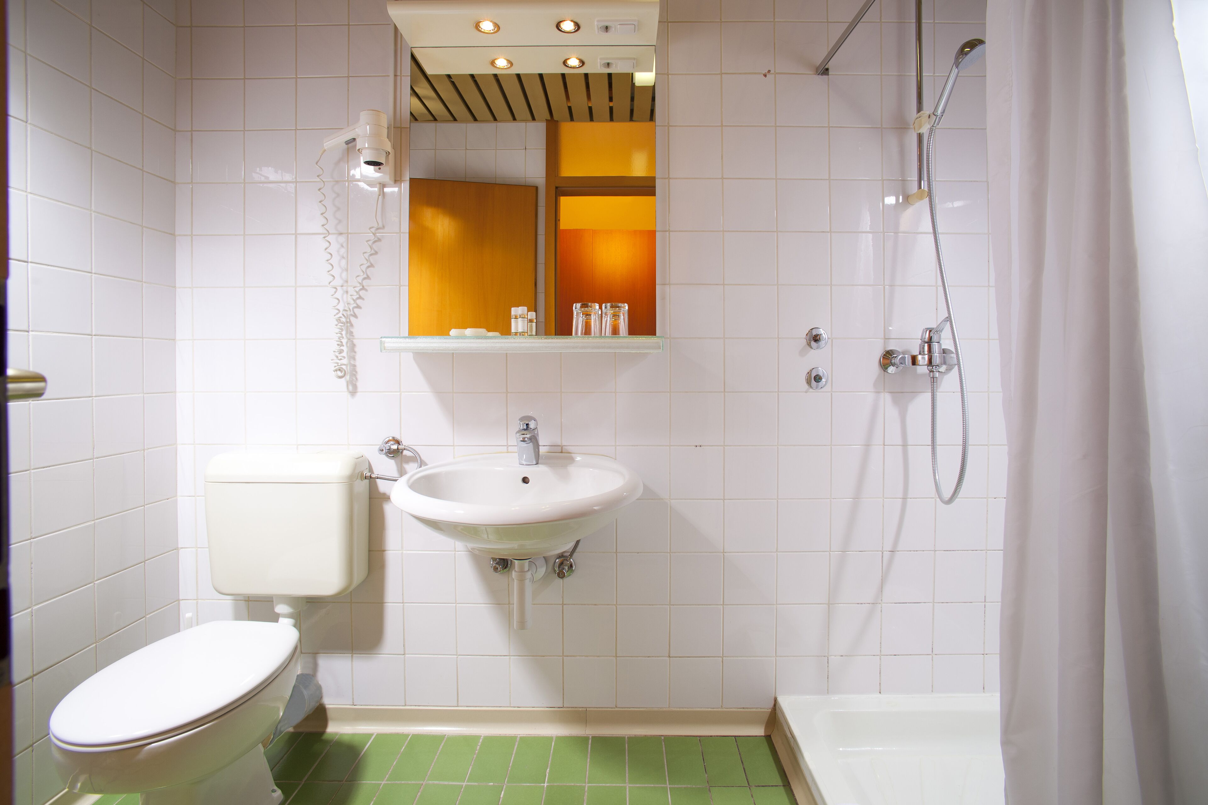 A bathroom with a toilet, sink, and shower.