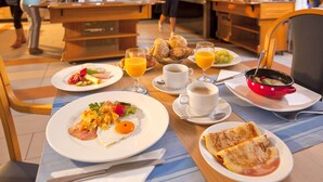 A breakfast buffet with various dishes, including eggs, toast, and fruit. - Hotel Vesna (Šoštanj)