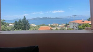 Quarto com vista para um lago, montanhas e casas.