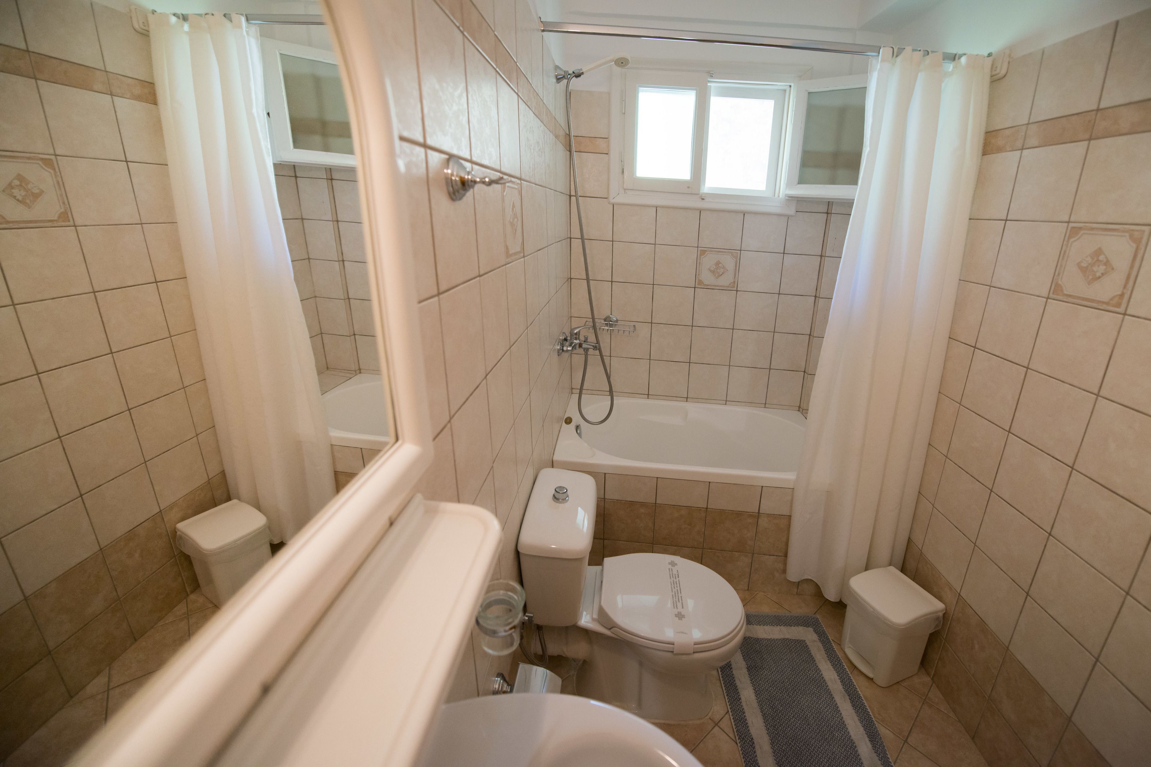 A bathroom with a bathtub, toilet, and shower.