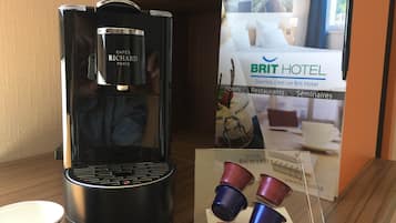 A coffee machine with a glass container labeled "CAFÉS RICHARD PARIS" and a brochure for "BRIT HOTEL" featuring a bed and breakfast setting.