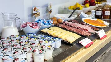 A variety of food items including cheeses, meats, and dairy products displayed on a counter.