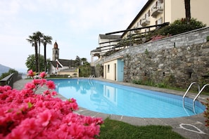 Una piscina al aire libre de temporada, tumbonas