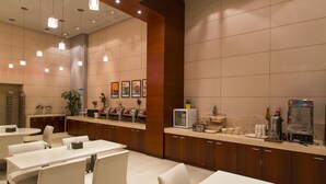 A modern hotel lobby with a reception desk, seating area, and a coffee station. - Jinjiang Inn (Jinan Daming Lake Baotu Spring) (Jinan)