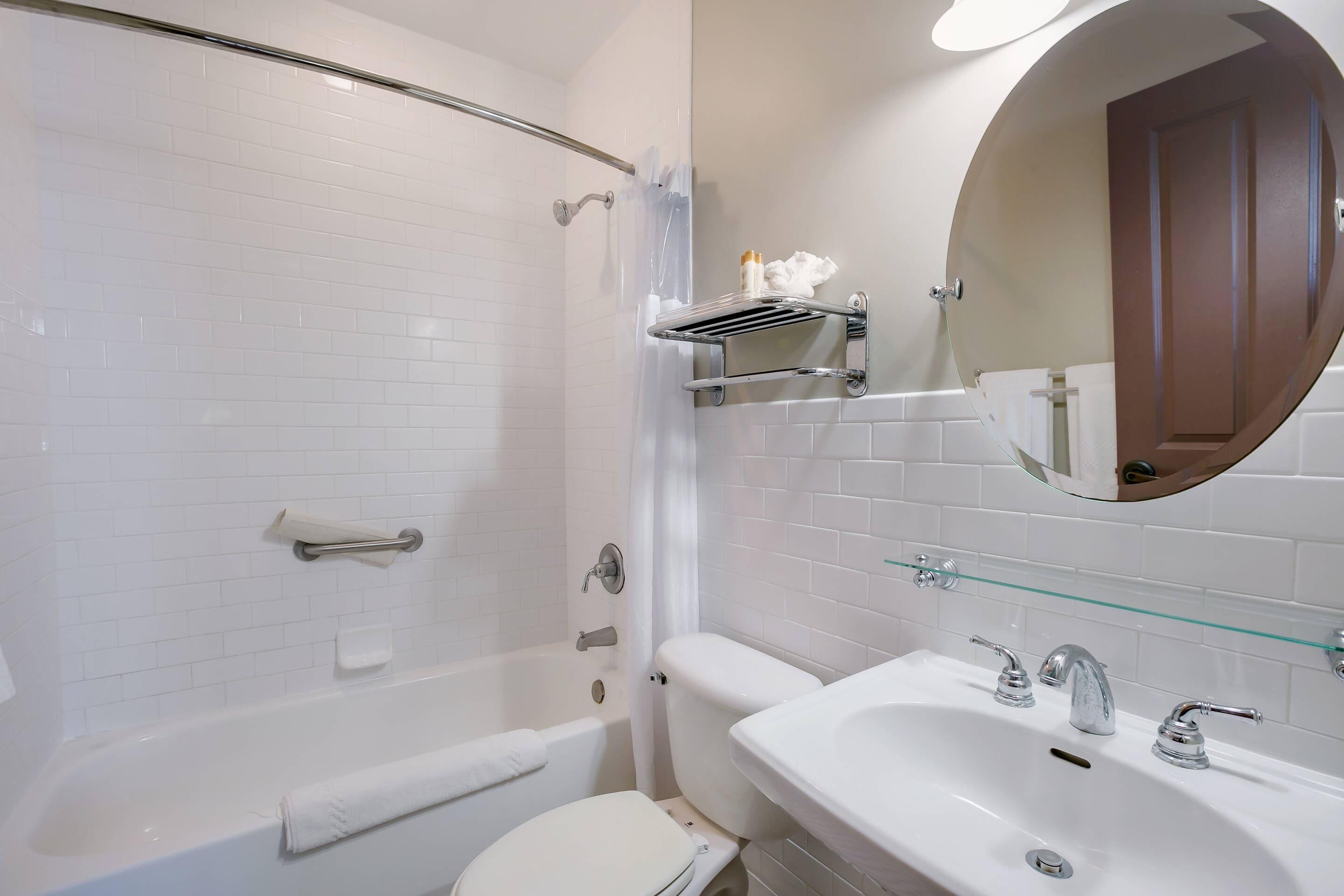 A modern bathroom with a bathtub, toilet, and sink.