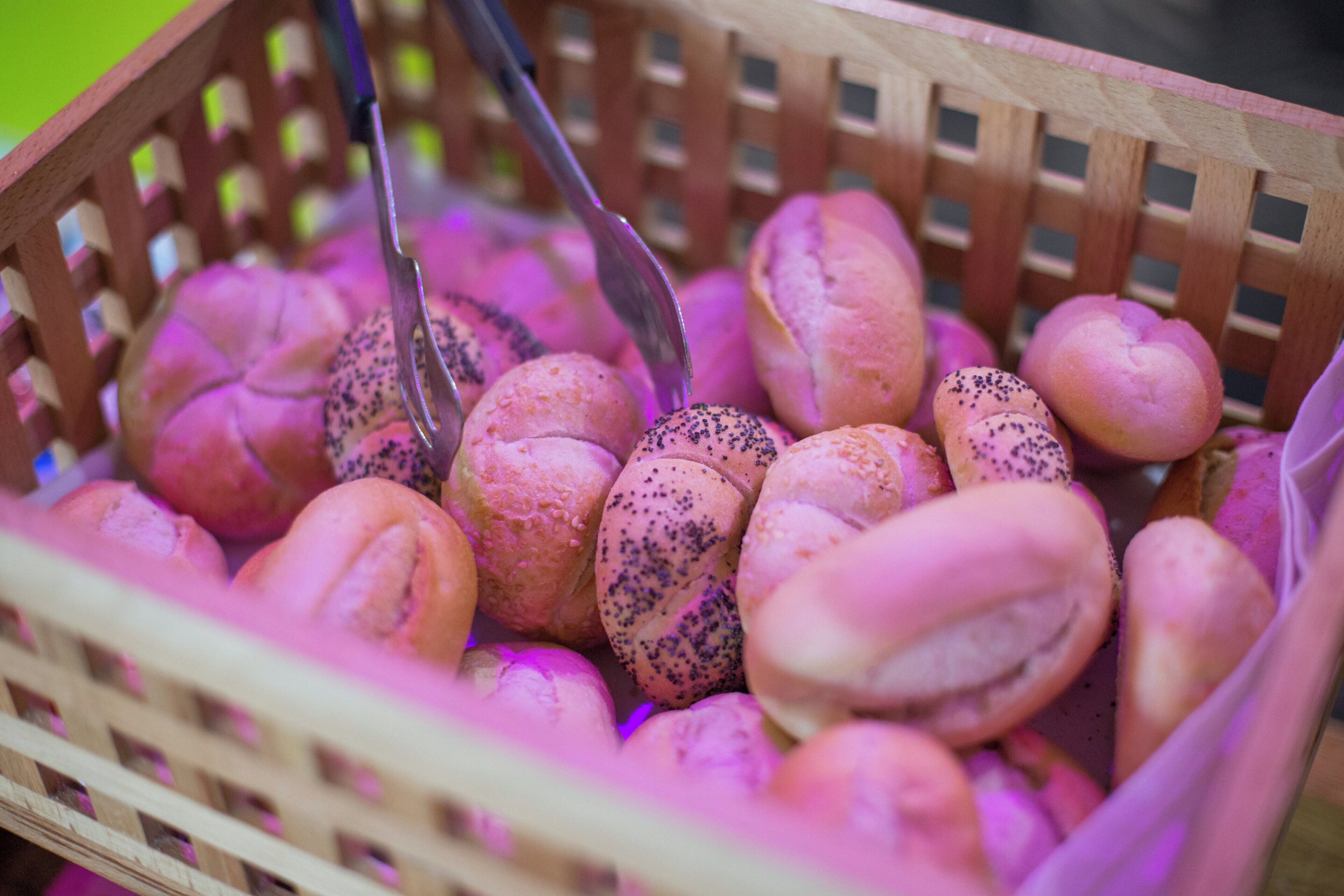 A wooden basket filled with various baked goods.