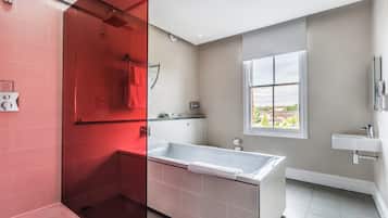 Un baño moderno con bañera, ducha y ventana que ofrece vistas.