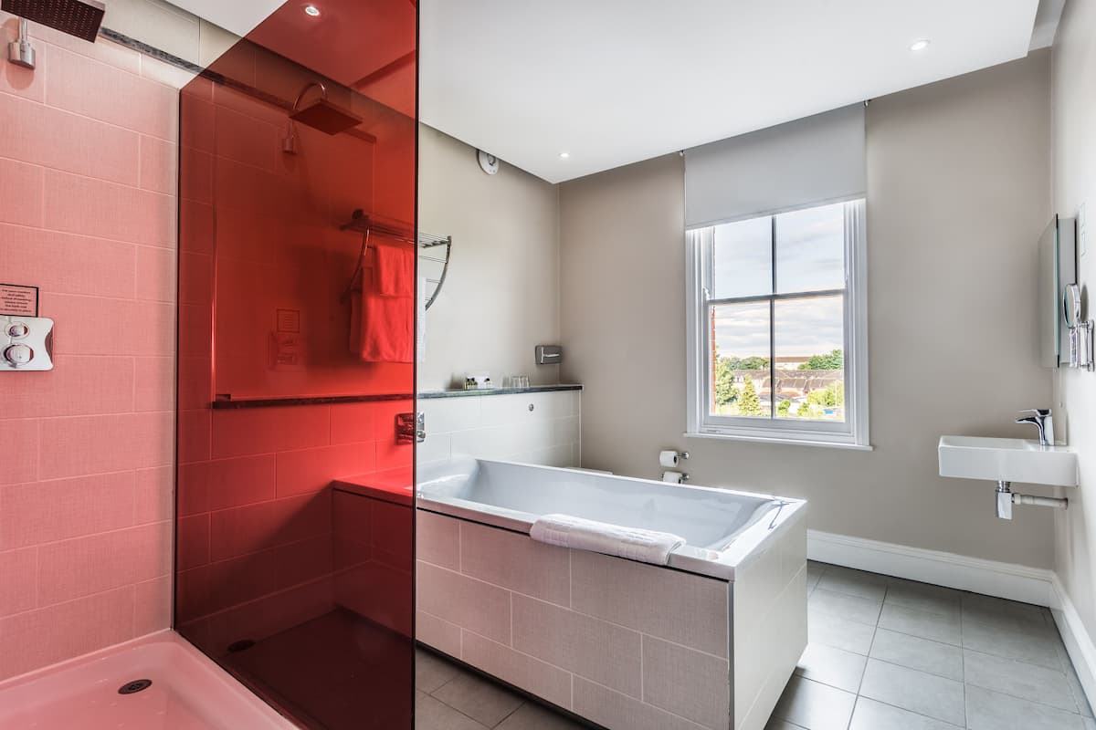 A modern bathroom with a bathtub, shower, and sink.