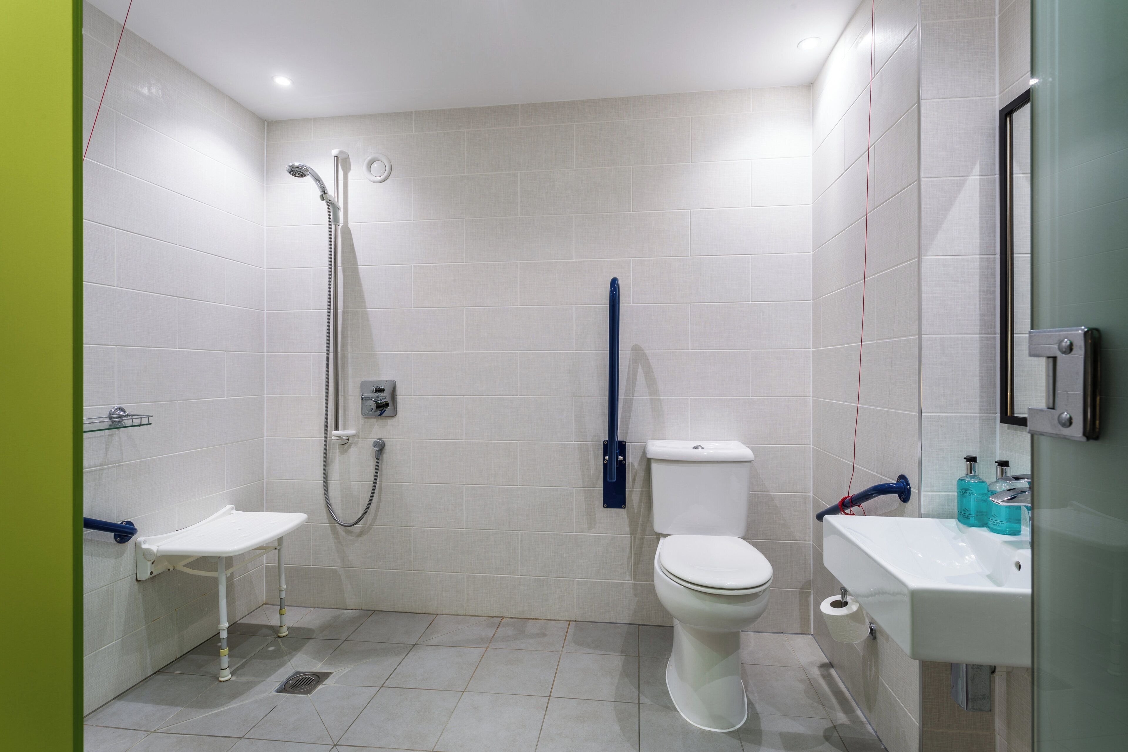 A modern bathroom with a shower, toilet, and sink.