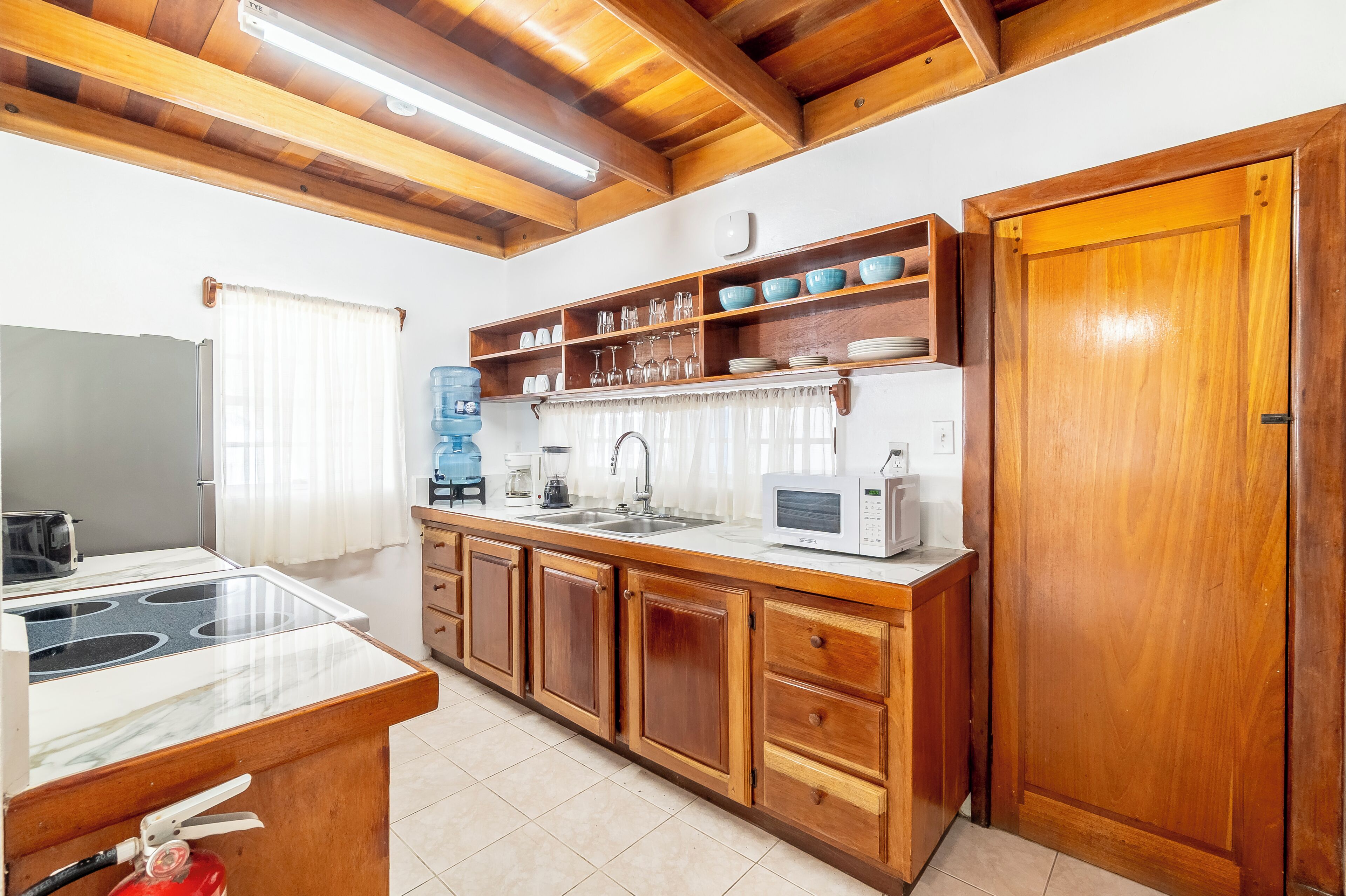 A kitchen with wooden cabinets, a microwave, a sink, and a stove.