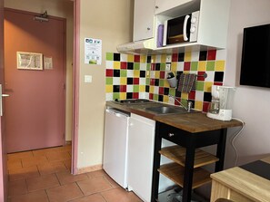 A compact kitchen with a microwave, sink, and a coffee maker. - AppartHotel Festival Sud Aqua - Gare TGV (Avignon)