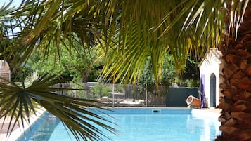 Een seizoensgebonden buitenzwembad, parasols voor strand/zwembad