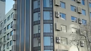 A multi-story building with air conditioning units, windows, and balconies.