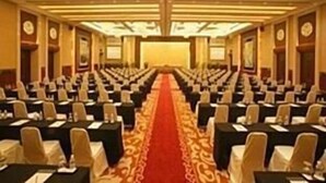 A conference room with rows of tables and chairs, a red carpet, and a chandelier. - Jinjiang Inn Nanjing Train Station (Nanjing)