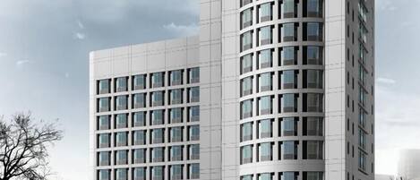 A modern multi-story building with a grid-like facade and large windows.