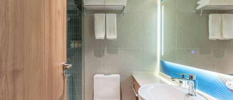 Un baño moderno con inodoro, lavamanos y toallero.