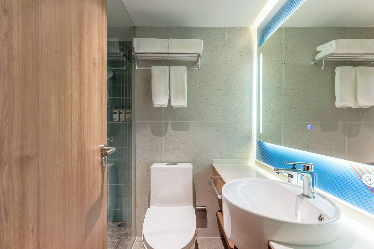 A modern bathroom with a toilet, sink, and towel rack.