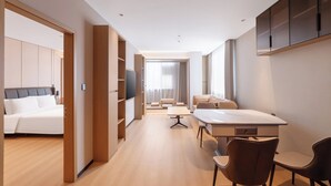 A modern hotel room with a large bed, a desk with chairs, a sofa, and a TV. - Holiday Inn Express Suzhou Shantang Street (Suzhou)