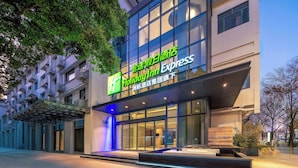 A Holiday Inn Express hotel with a modern facade, large windows, and a well-lit entrance. - Holiday Inn Express Suzhou Shantang Street (Suzhou)