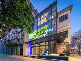 A Holiday Inn Express hotel with a modern facade, large windows, and a well-lit entrance.