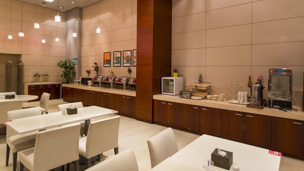 Un moderno vestíbulo de hotel con mostrador de recepción, zona de estar y estación de café.