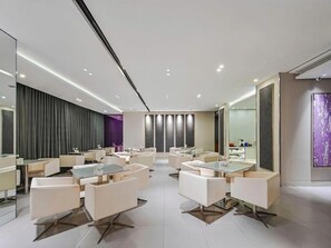 A modern hotel lobby with multiple seating areas, a large mirror, and a reception desk. - Jinjiang Inn ( Wuxi Liangqing road Wanda Plaza canal Bay Industrial Center store) (Wuxi)