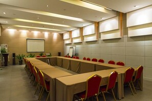 A conference room with a long table, red chairs, a projector screen, and a whiteboard. - Jinjiang Inn Wuxi Wangzhuang Road E (Wuxi)