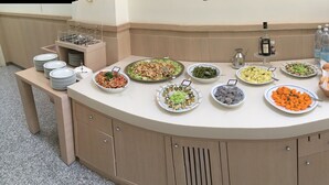 A buffet setup with various dishes, a coffee machine, and a water dispenser. - Hotel Europa (Foggia)