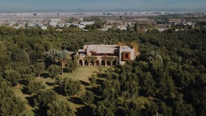 An aerial view of a property surrounded by dense greenery, featuring a central building with a courtyard and multiple arches. - Sirayane Boutique Hotel and Spa (Marrakech)