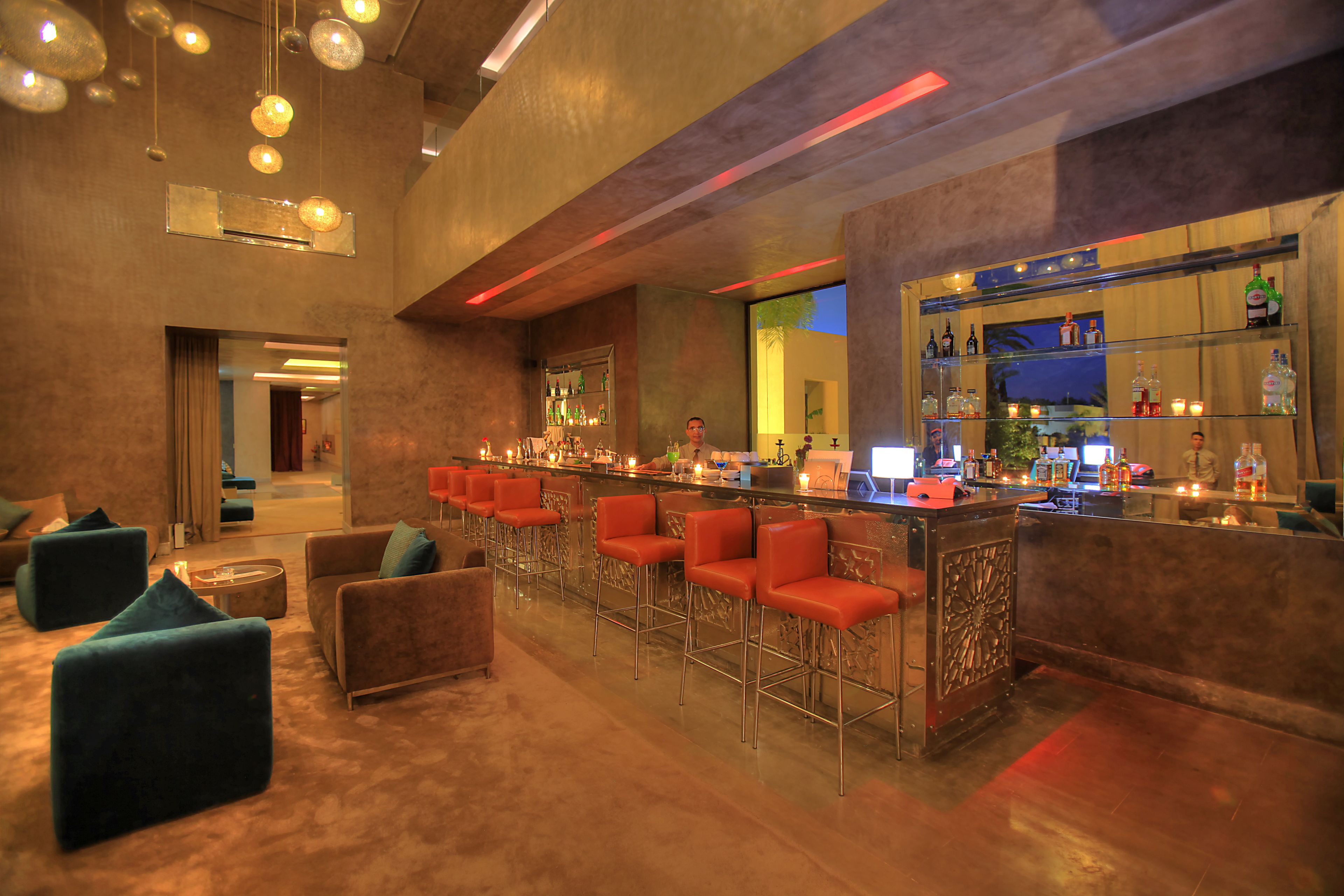 A bar area with multiple seating options, including bar stools and sofas, and a well-stocked bar counter.
