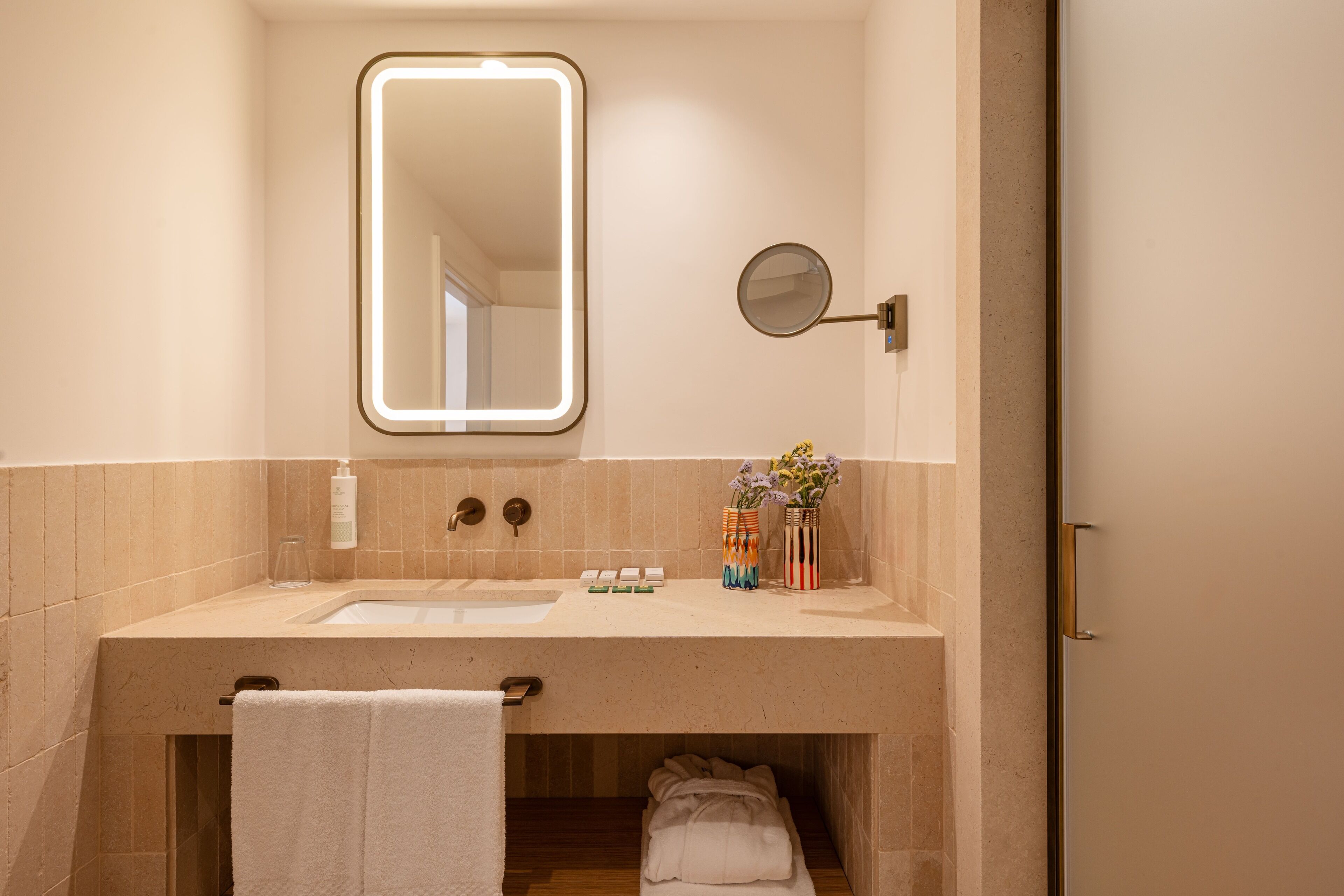A bathroom with a sink, mirror, and towel rack.