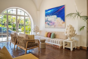A living room with a sofa, chairs, a coffee table, a painting, and a plant. - Ostuni a Mare (Ostuni)