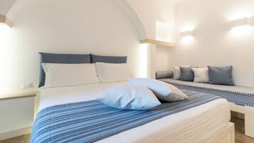 Un dormitorio moderno con una cama grande, un banco y un techo curvo.