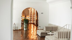 A modern interior with a wooden floor, a sofa, a small table, and a bookshelf. - Ostuni a Mare (Ostuni)