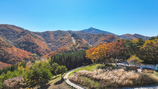 A mountainous landscape with a winding road and a bench area for visitors.