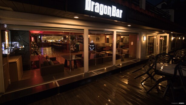 Un bar appelé « Dragon », avec une terrasse et un sapin de Noël.