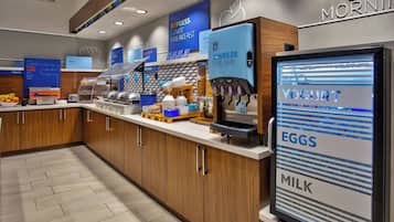 A breakfast bar with a yogurt dispenser, a coffee machine, and a sign advertising 'Good Morning'.