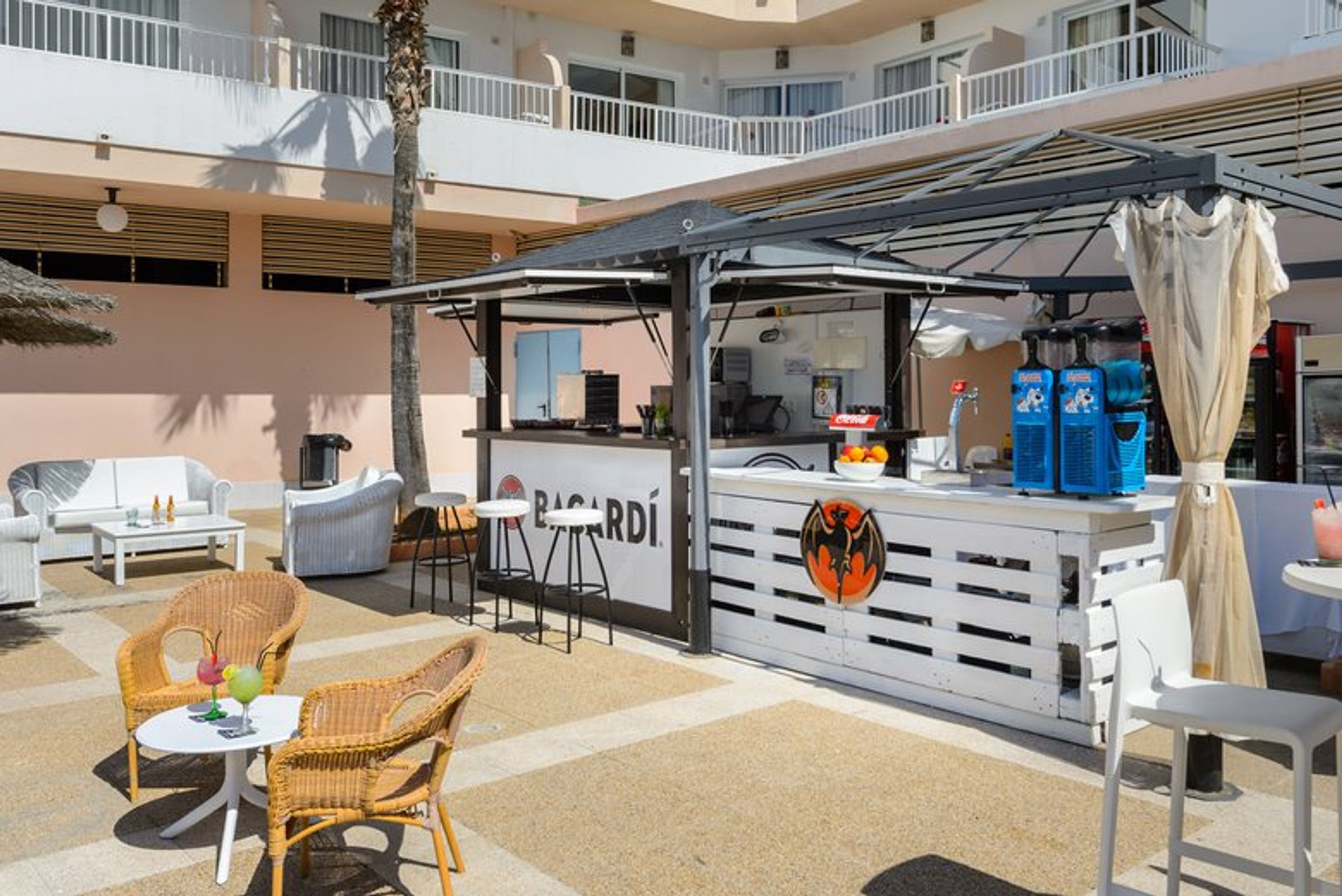 An outdoor bar area with wicker furniture and a white counter.