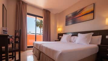 Een hotelkamer met een groot bed, een bureau en uitzicht op de omgeving.