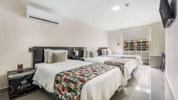 A hotel room with two beds, a minibar, an air conditioner, a flat-screen TV, and a window with a view.