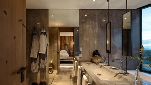 A modern bathroom with a large mirror, a bathtub, and a shower area.