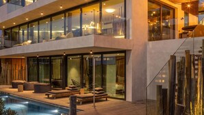 A modern multi-story building with large glass windows, a rooftop terrace, and a swimming pool. - Areias do Seixo Charm Hotel & Residences (Torres Vedras)
