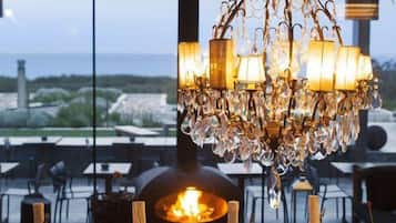 A dining area with a chandelier, table set for a meal, and a view of the outdoors.