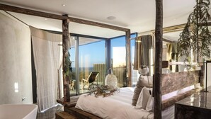 A modern bedroom with a large bed, a bathtub, and a view of the city. - Areias do Seixo Charm Hotel & Residences (Torres Vedras)