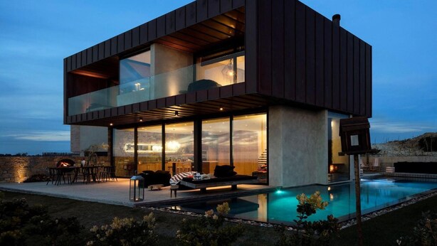 A modern two-story house with a glass facade, outdoor seating, and a swimming pool. - Areias do Seixo Charm Hotel & Residences (Torres Vedras)