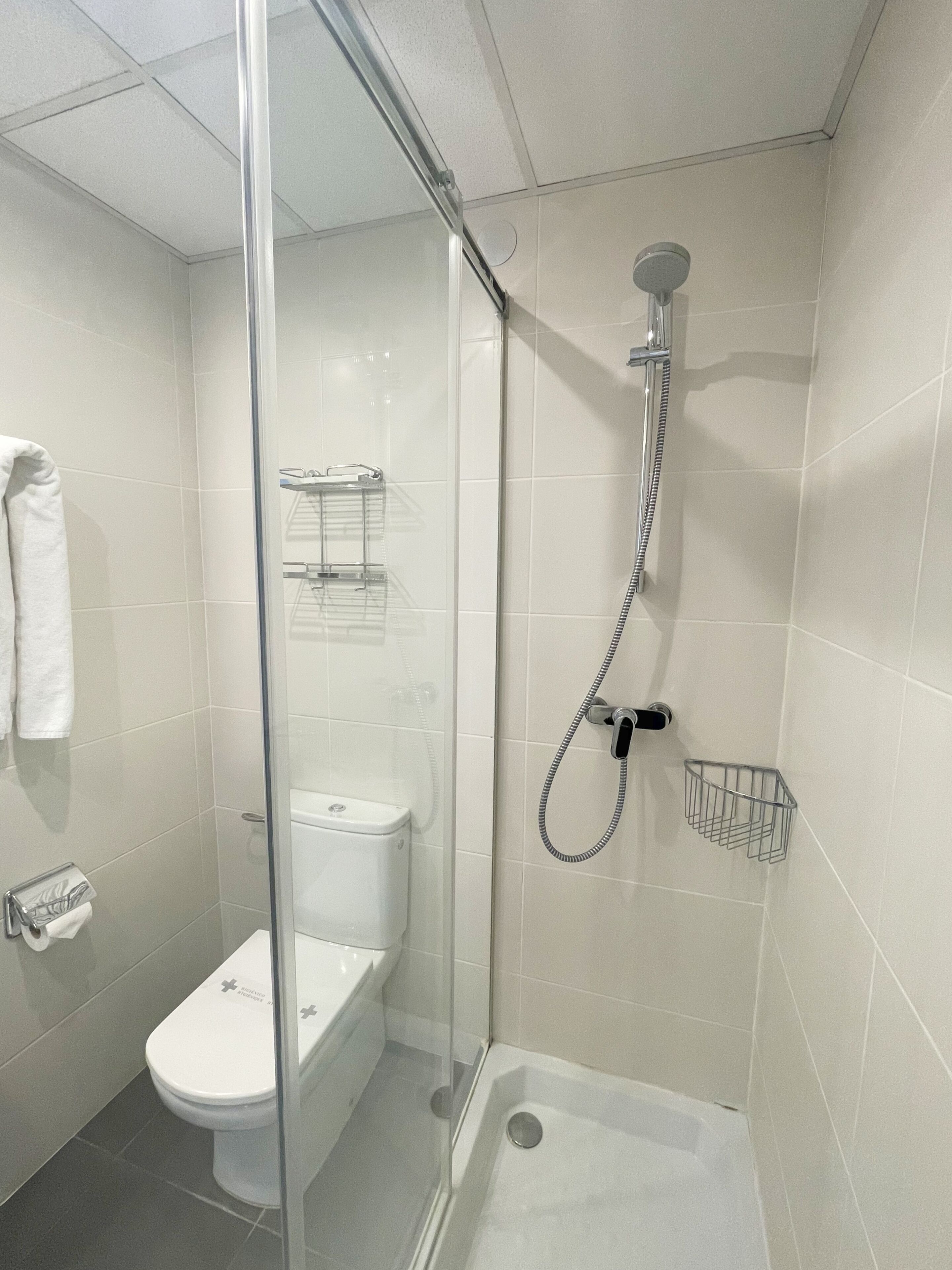 Et moderne badeværelse med en brusekabine i glas, toilet og badekar.