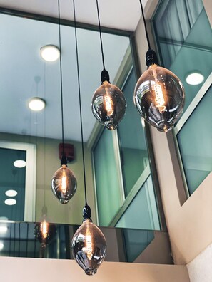 A modern interior with hanging spherical light fixtures and a visible staircase.