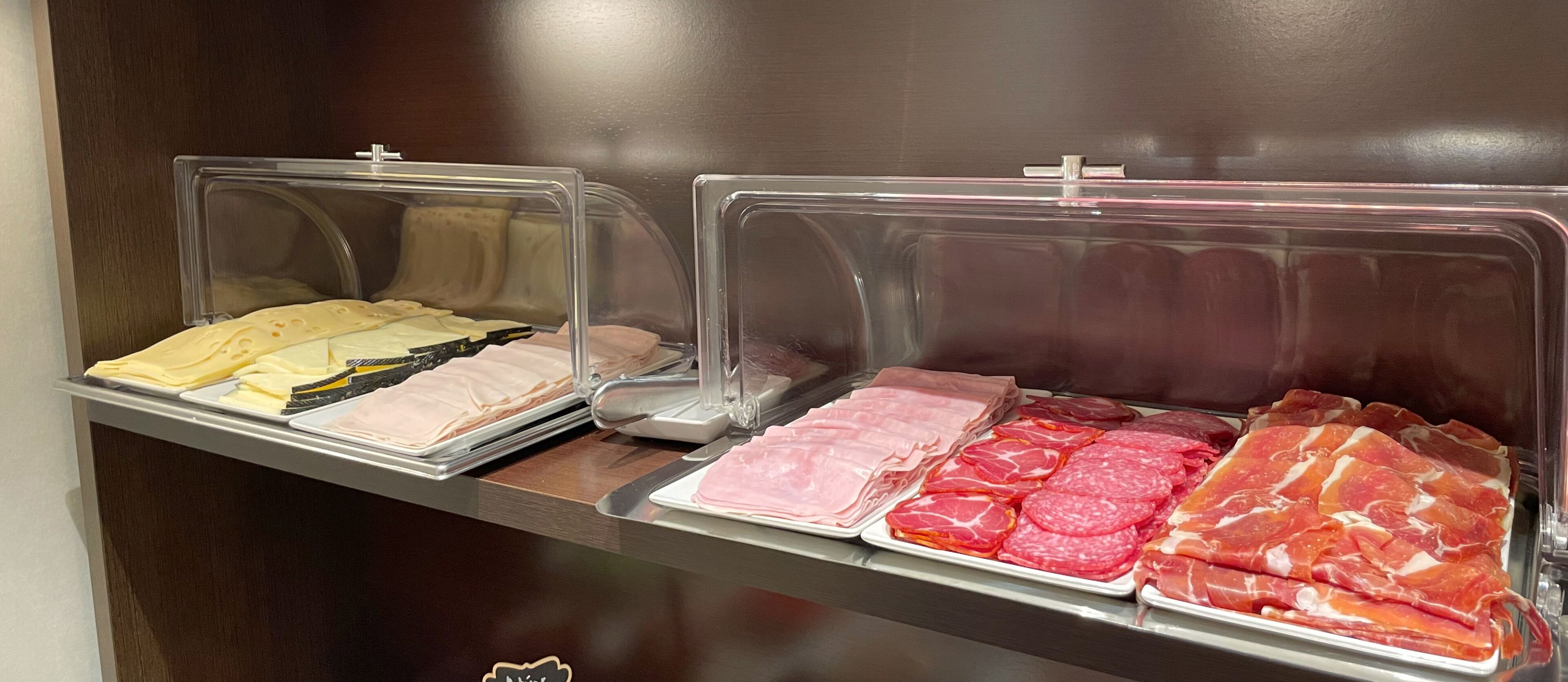 Une présentation de produits alimentaires comprenant différents types de fromages et de charcuteries.
